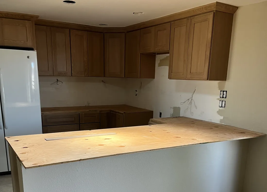Kitchen remodel in progress: new oak cabinets installed and countertops templated
