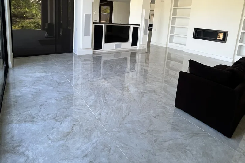 Large-format polished porcelain tile floor styled like Taj Mahal quartzite in an open living room, Palm Desert